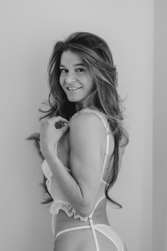 Portrait einer Frau im Boudoir-Studio mit natürlichem Licht und ruhiger Stimmung in Schwarzweiß